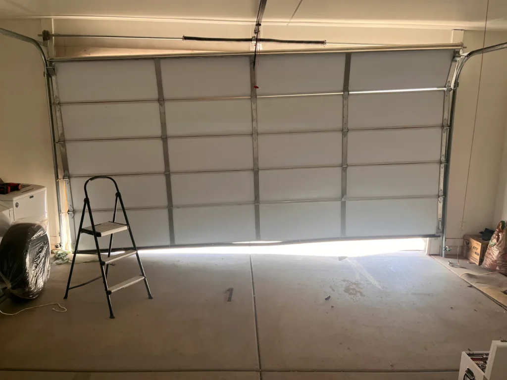 Garage door repair technician working on a residential garage door in Phoenix, AZ
