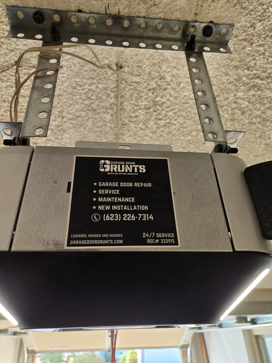 Garage door opener with a Garage Door Grunts service sticker in Sun City, AZ