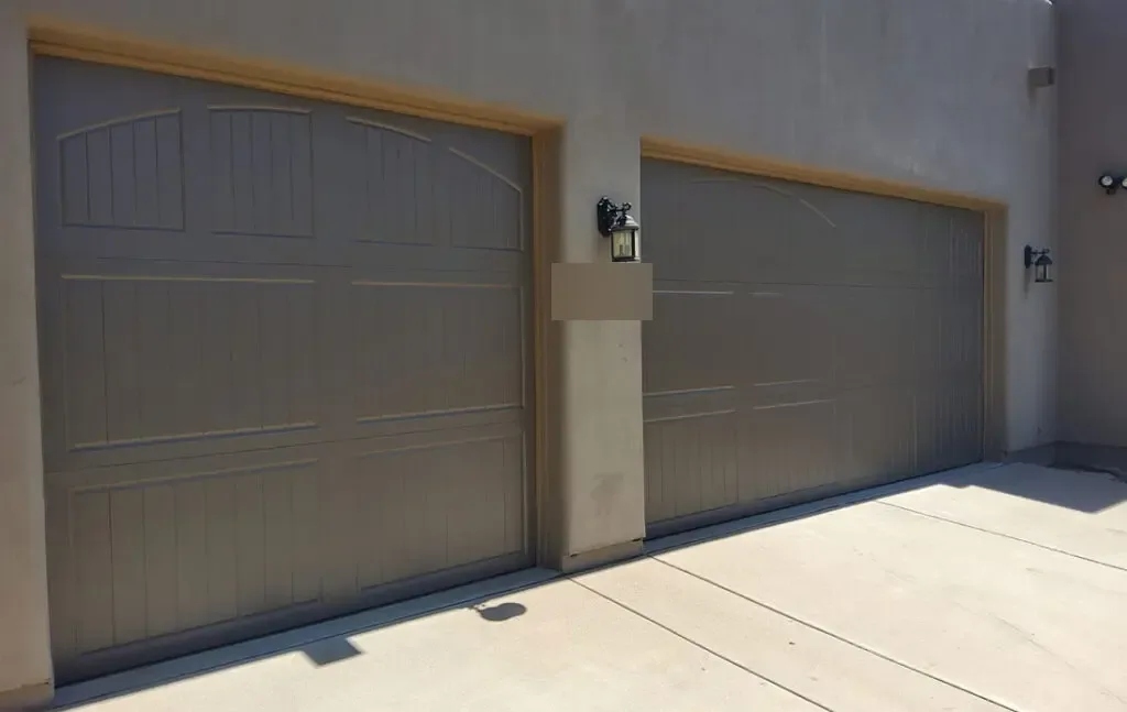 Beige modern flush garage doors at a courtyard entry